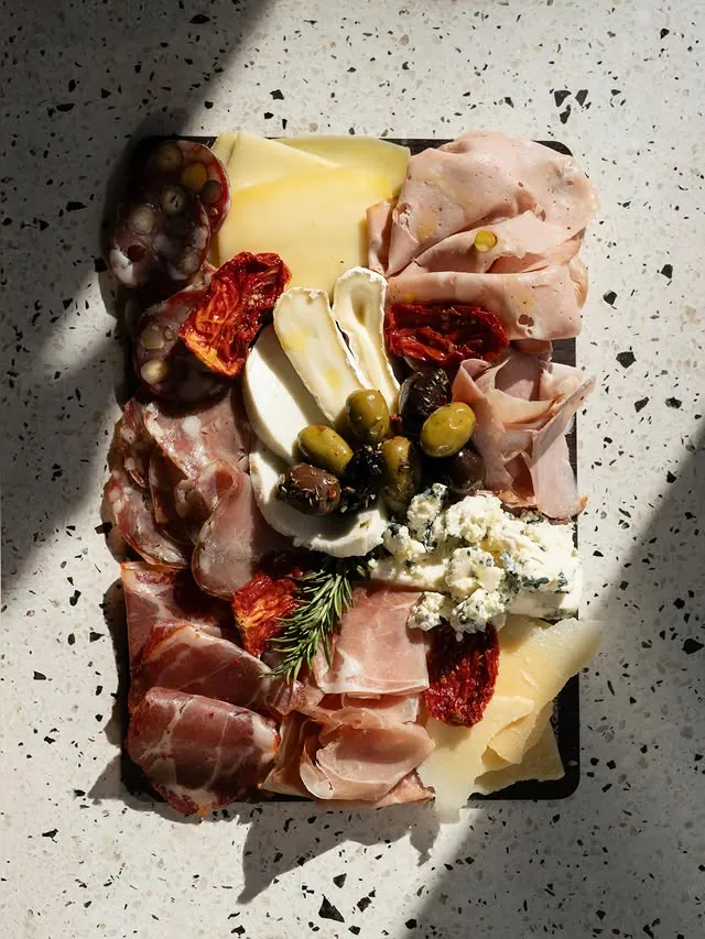Tabla de salumi y quesos sobre granito