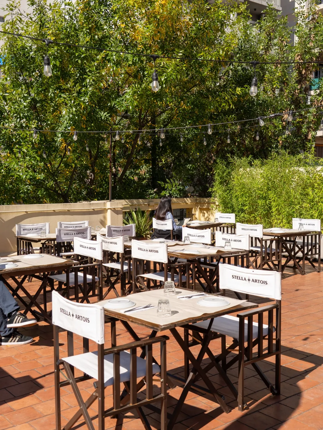 Terraza de La Alacena de día, con mesas y guirnaldas de luces